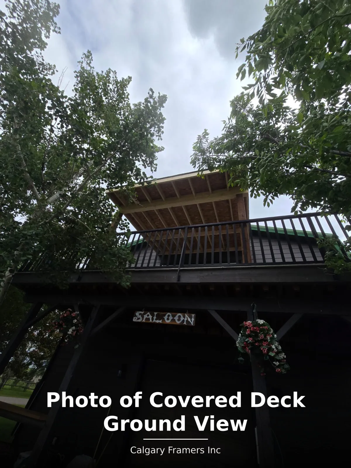 Shed-roof covered deck framed over an existing elevated deck, viewed from ground level