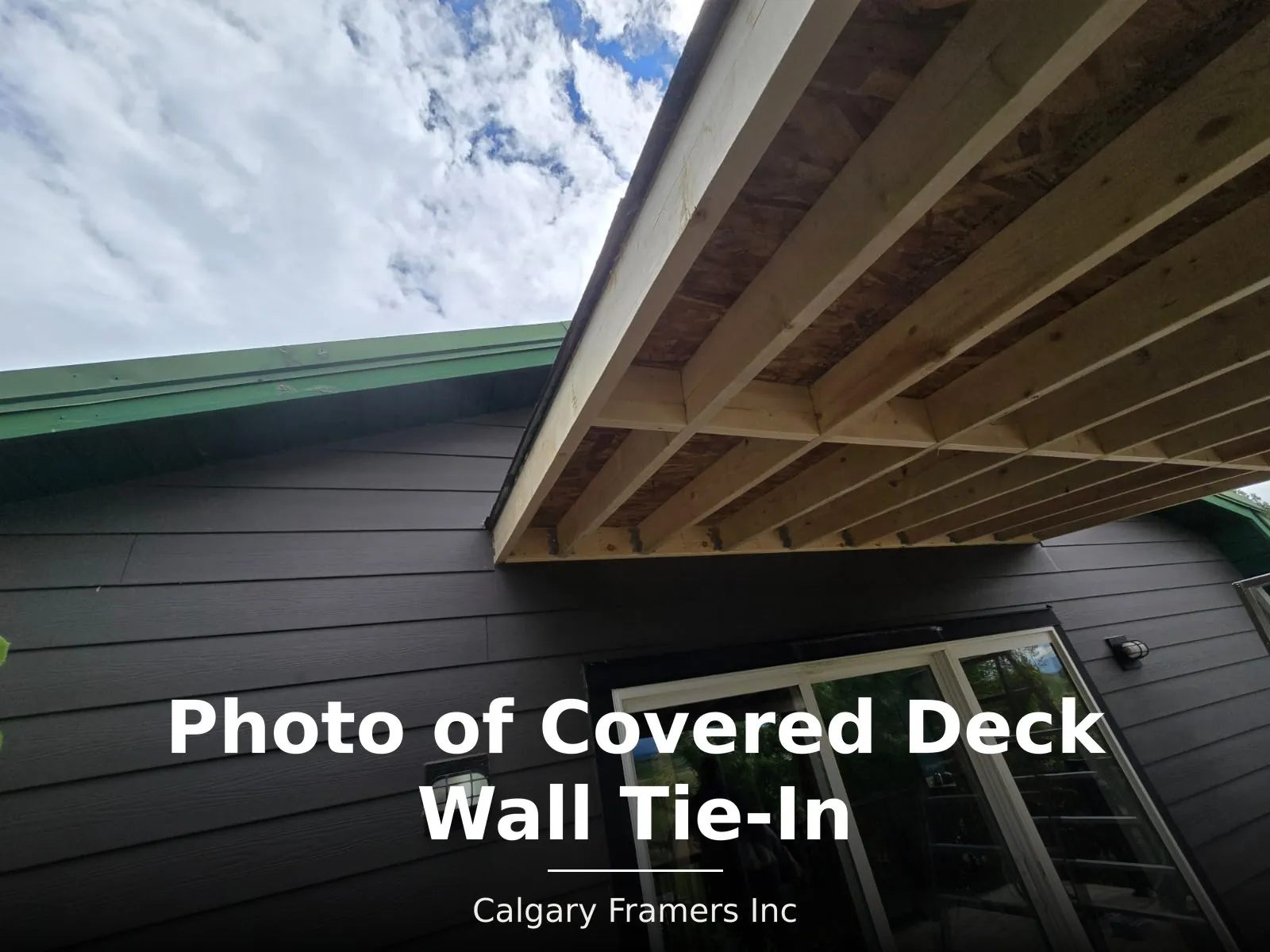 Covered deck roof framing tied into the house wall above sliding patio doors