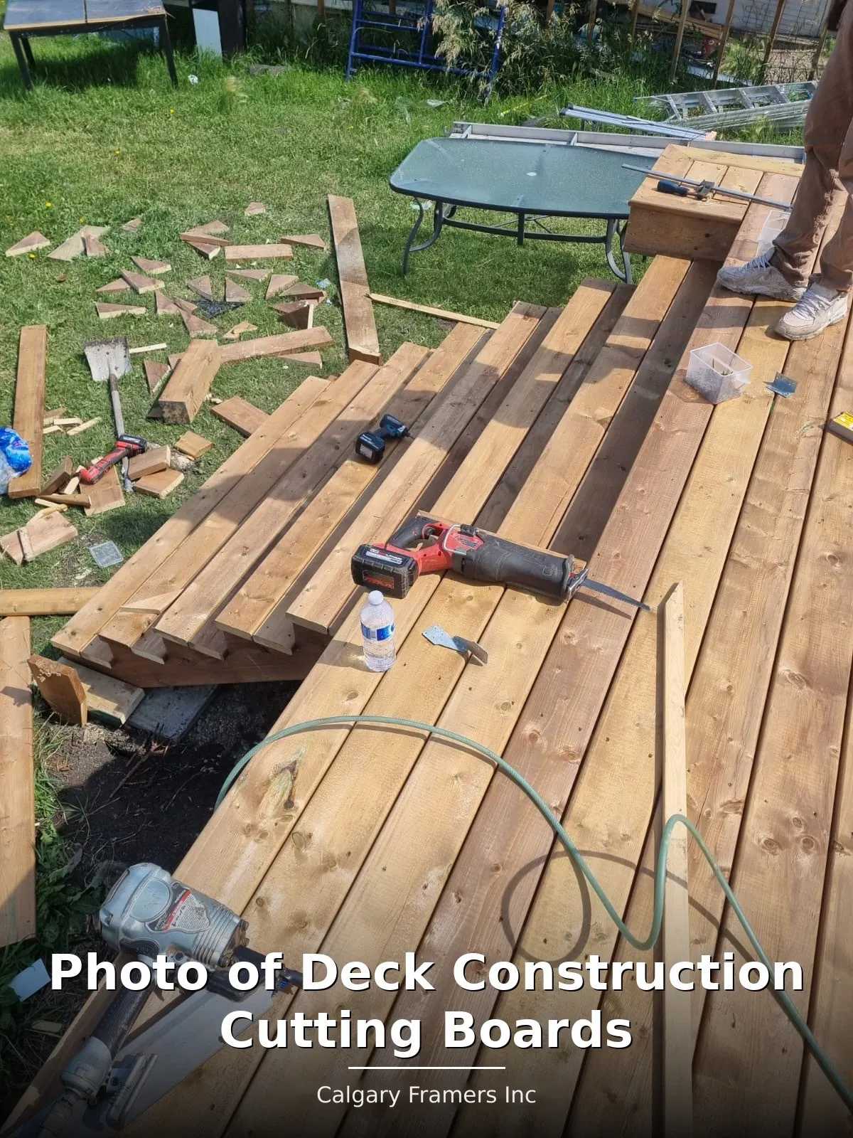 Deck boards being cut to length on site during a Calgary deck build