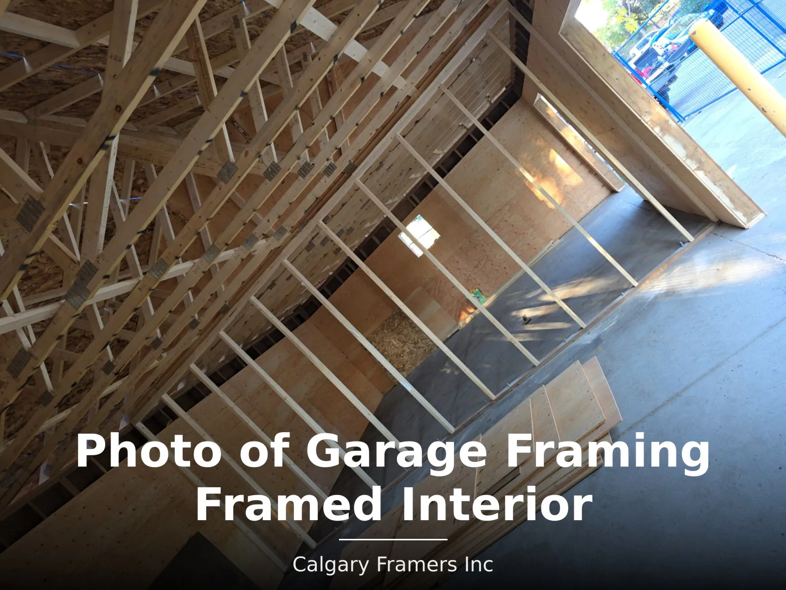 Framed garage interior with sheathed walls and roof trusses overhead
