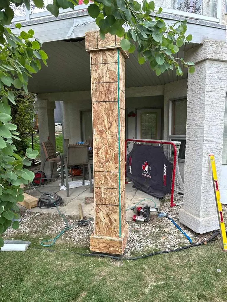 Water-damaged deck column and stucco siding before structural restoration